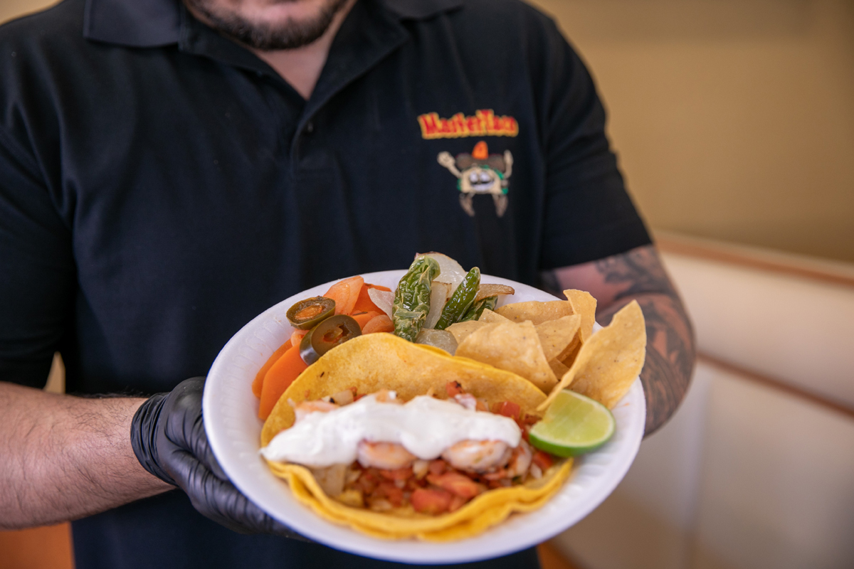 Man holding plate of Mexican food